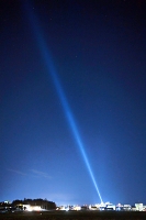 塩尻市のホテルから夜空に延びるサーチライトの光＝昨年１２月、松本市小屋南から撮影