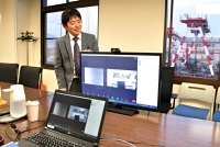 オンラインの説明会などに使うパソコンとモニターを前にする山岸さん。２４日の説明会もオンラインで行った