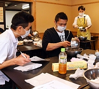 小池さん（右奥）の指導で入野谷在来そばのパンを試作する菓子店主ら