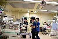 深夜、新生児集中治療室で回診中の医師と看護師。４０人ほどの赤ちゃんを昼夜を問わずケアし、命を守る