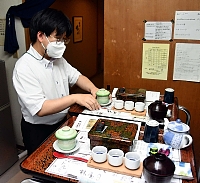 テイクアウトのうな重などの料理を客室に届ける準備をする従業員