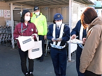 啓発運動で反射材付きのトートバッグを配布する北條組の社員（左端）ら