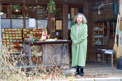 薬草店の前に立つ萩尾さん