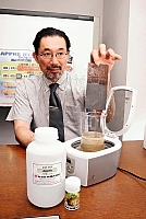 さびた鉄板をアップル液に漬け、効果をＰＲする白鳥社長