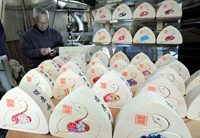 南木曽町の名物、おにぎり形の干支の置物 木工作家、上向く蛇を丁寧に