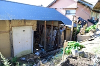 長野市の「すけろくガーデン」で、廃材を利活用して鶏小屋を造る信州大の学生たち。左が空き家だった古民家＝１１月下旬