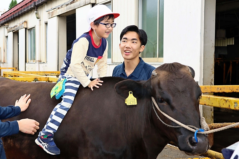 牛の背中に乗ってみた…怖がる子どもに「人懐っこいから大丈夫」 伊那市