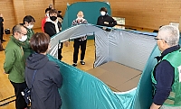 強度行動障害の状態を踏まえ、テントの高さや入り口の向きなどを議論する参加者ら＝５日、中野市