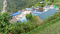 斜面にへばり付くようなパウダル村。左奥に地滑り地が見える。手前は小学校