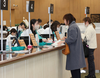 新たな行名やロゴマークが入った法被を着て営業初日の業務に臨む職員たち＝5日午前9時27分、長野市の八十二長野銀行本店営業部