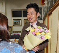 比例代表での初当選が決まり、花束を手に笑顔を見せる若狭清史さん＝9日午前0時39分、長野市稲里町田牧