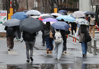 雨の中、試験会場に向かう受験生＝25日午前8時31分、松本市の信大松本キャンパス