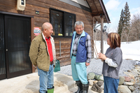 改修した古民家の前で今後の坪野集落について話す斎藤一平さん（左）、妻の弘美さん（右）と区長の斎藤一三さん（中央）＝7日、栄村