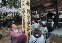 それぞれの願いを胸に、回向柱に触れる参拝者