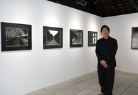 写真展の会場で、作品について話す阿部さん