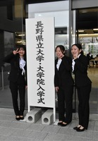 看板の前で記念写真に納まる新入生たち