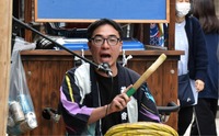 奈良井宿での春祭りで太鼓を鳴らしながら歌う加藤さん＝4日、塩尻市奈良井