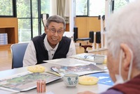 泰阜村のサロンで中国帰国者に話しかける勝野さん＝2025年9月