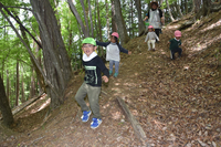 高遠北おやまの保育園の裏山を駆け回る子どもたち。園児減少による休園を回避し、自然を生かした保育が移住者らを引き付ける＝20日、伊那市高遠町藤沢