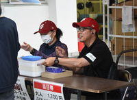 試合前に入場券を販売する長野県民球団の味方健二郎社長（右）