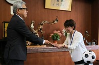 サッカーボールの目録を受け取る山形小学校の百瀬校長（右）