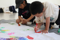 大きな旗に絵を描く小学生