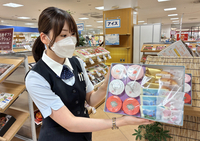 ギフトの菓子を持つ販売員