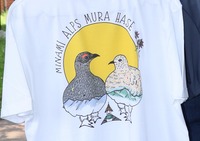 ライチョウや道の駅の外観のイラストが描かれたTシャツをPRする福島さん