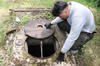 簡易水道の水源を確認する菊原さん＝6月23日、南相木村
