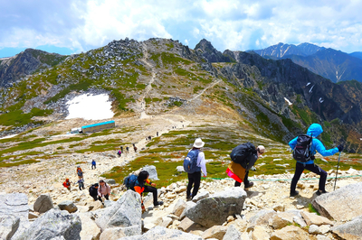 木曽駒ケ岳への道に列をなすように続く登山者たち。立ち止まっては南へ連なる稜線を眺めた＝6月13日午前11時14分