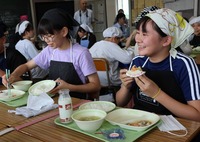 給食でフランスの焼き菓子を味わう児童（右）ら＝13日、御代田町