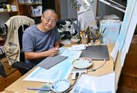 　アトリエの机で新作を描く絵本作家の舘野鴻さん＝神奈川県秦野市