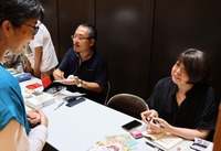 トークイベント後の即売会で著書にサインをする（右から）ねこ沢ふたよさん、麻根重次さんら