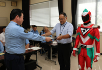 根橋署長（左）から感謝状を受け取る斎藤さんとダイコンレッド