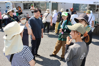 地域おこし協力隊員の小林さん（中央右）らと交流するツアーの参加者たち