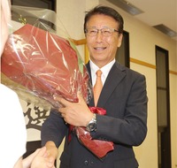 3選を果たし、花束を手に支持者と握手する横前明氏＝9日午後9時8分、泰阜村平島田