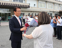 職員の出迎えを受けて初登庁する横前村長（左）