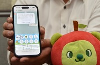 長野地域を巡るデジタルスタンプラリーの画面を見せる竹内さん