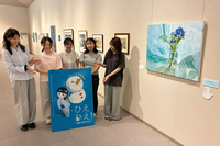 涼しげな絵などが並ぶ会場で「あおまる」や「すずこ」のパネルを囲む学生たち