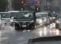 激しく雨が打ち付ける中、水しぶきを上げて走る車＝27日午前8時44分、長野市鶴賀七瀬