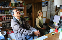 三伏峠小屋の受付カウンターに座る管理人の宗像充さん（左）とマネージャーの椎名美恵さん＝7月21日、下伊那郡大鹿村