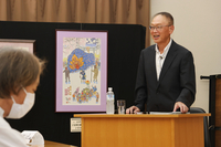 北島さんの絵を傍らに生涯について話す北沢さん