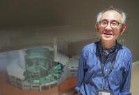 　京都大の研究炉模型の前の五十嵐康人さん