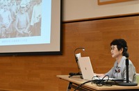 スライドで写真や資料を紹介しながら朗読をした知久さん
