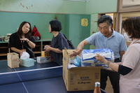 不用品の回収日におむつや服などを地域活動支援センターに持ち込む住民ら＝8月28日