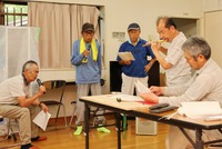 榑木踊りの練習会で、笛などの音に合わせて歌を確認する高島さん（左から2人目）ら村民
