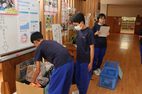 高森中学校の回収箱に子供服を入れる生徒