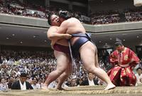 寿之富士の攻めをこらえる御嶽海（左）。寄り倒しで敗れる＝両国国技館
