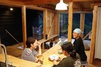 ゲストハウス「ORION」で談笑する村沢さん（右奥）、宮沢さん（左）ら