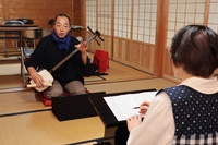 三味線を手に太夫の稽古をつける鶴沢さん（奥）